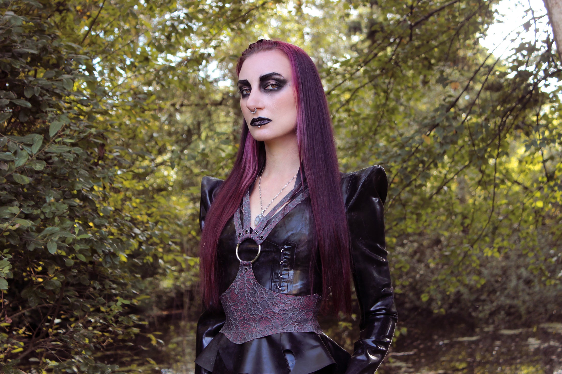 Detail of the shaped peplum and double-breasted side fastening on the latex Sin jacket