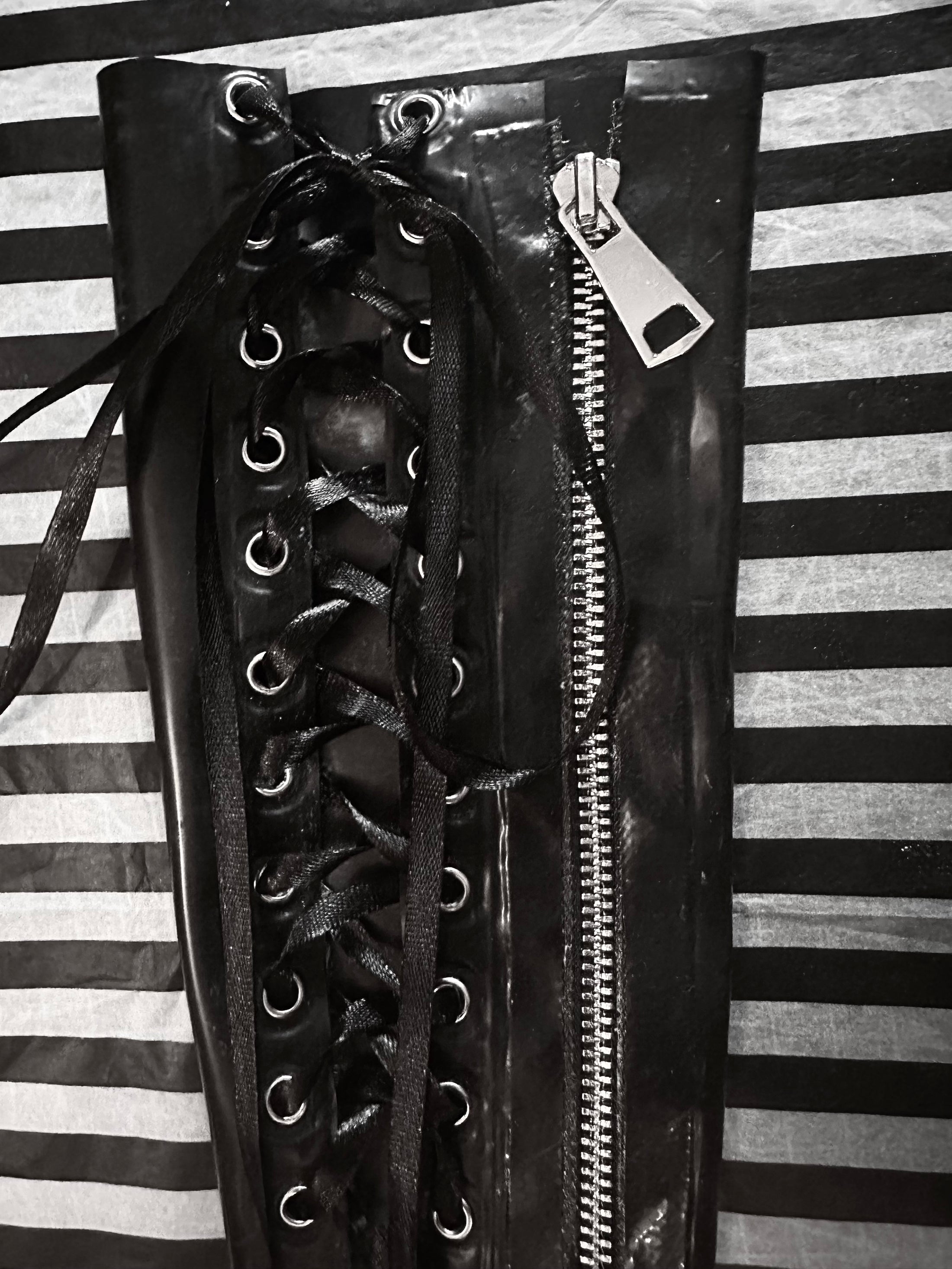 Texture detail of the smooth latex on the lace-up zipper gauntlets