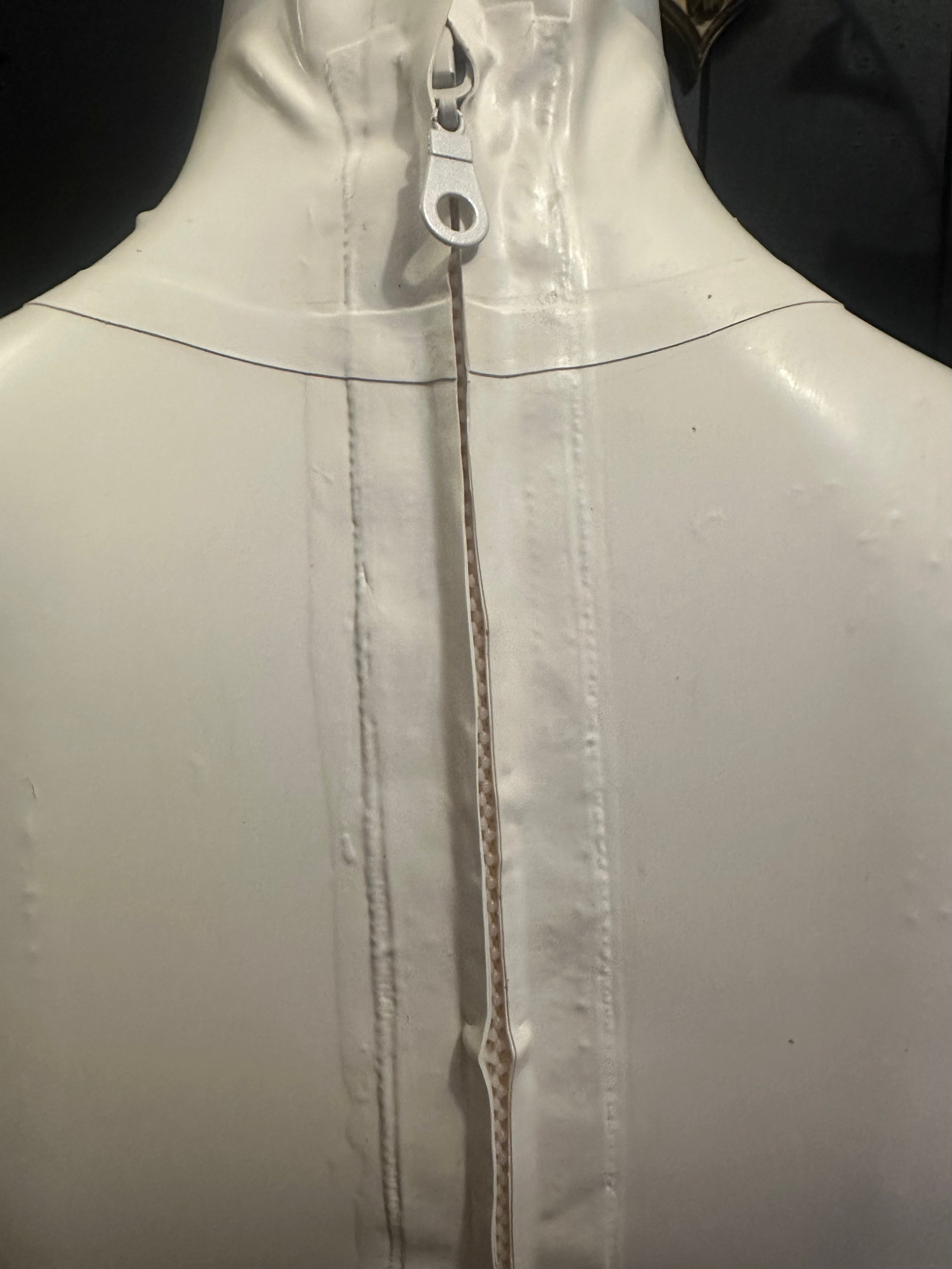 Close detail of the white latex mini skirt finish and fit of the set