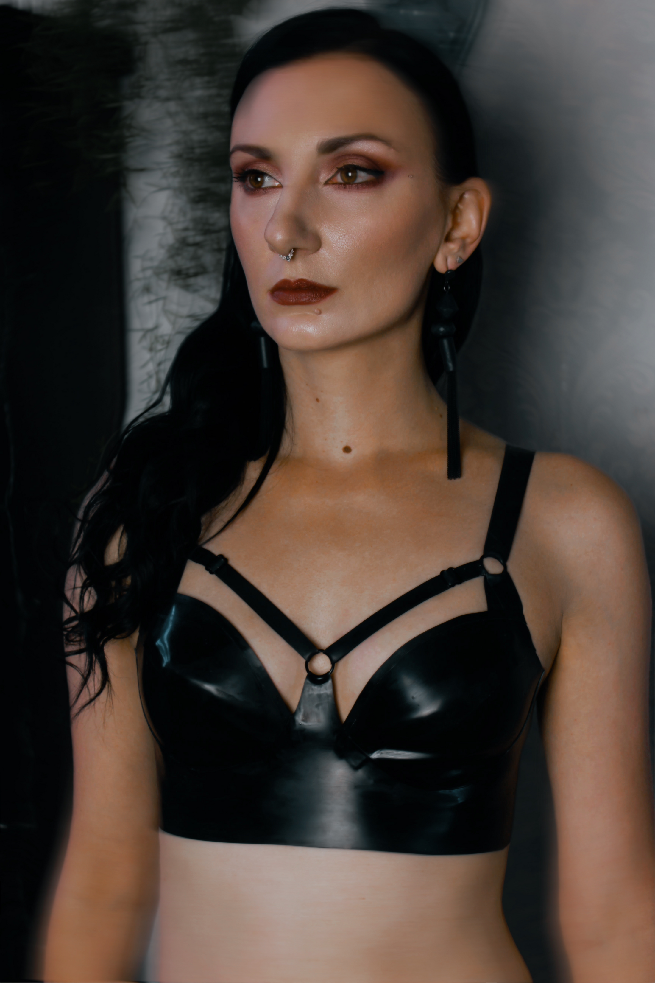 Detail of the adjustable harness straps across the chest on the latex bra