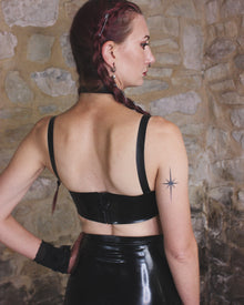 Fit detail of the wearable latex Buckle crop top with silver buckles and eyelets