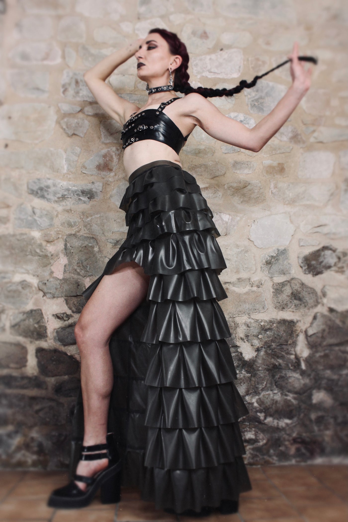 Close detail of the hand-pleated ruffle layers adding texture and movement to the latex skirt
