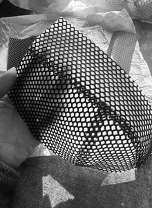 Close detail of the centre-back fastening on the latex-net bra