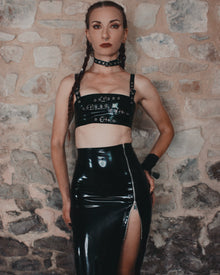 Close detail of layered latex bust straps with silver buckle hardware on the Buckle crop top