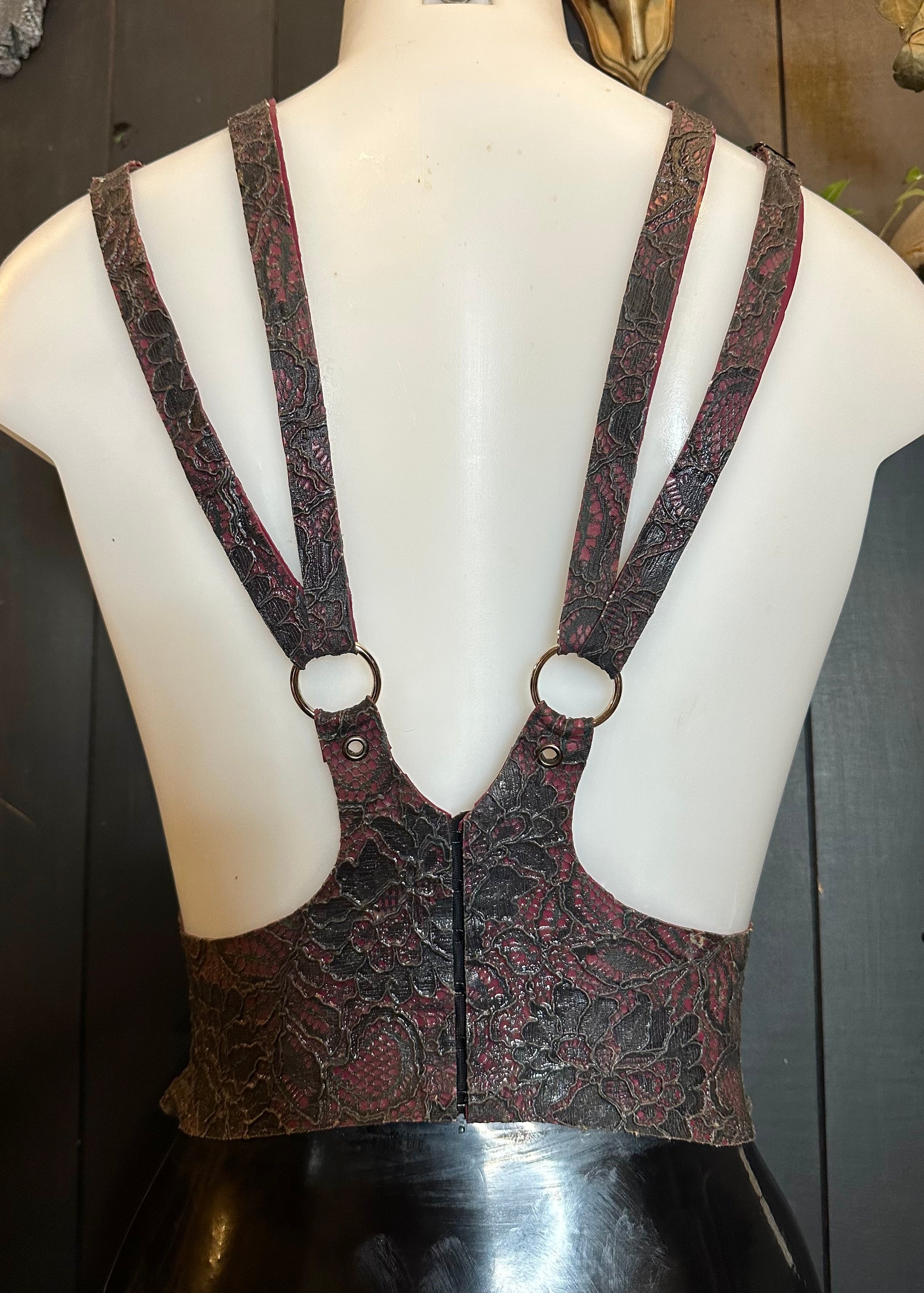 Detail of the adjustable straps and cinched fit on the latex-lace harness sample