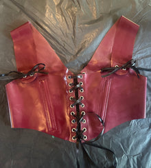 Detail of the lace-up corset lacing on the cropped latex top