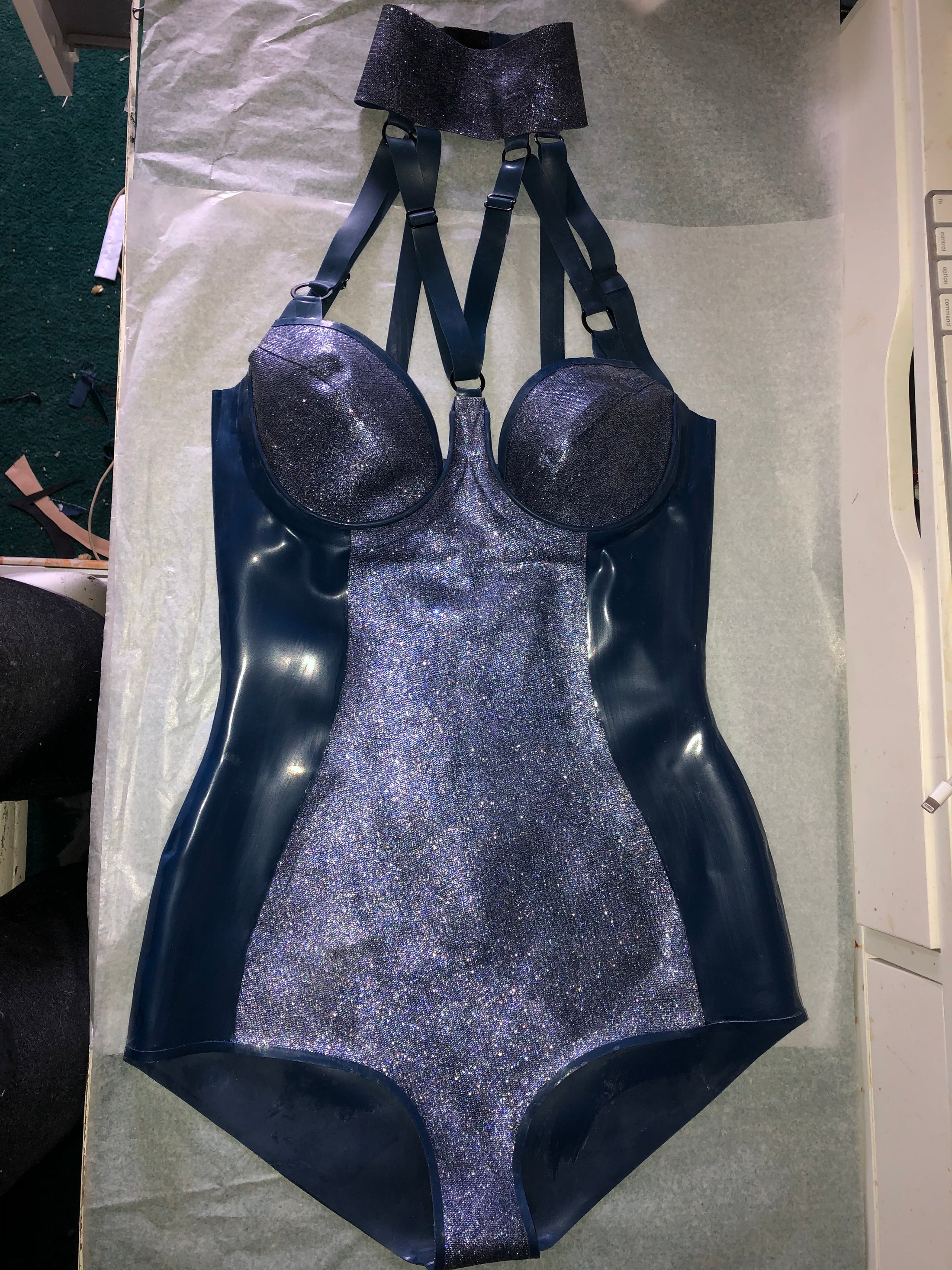 Texture detail of the blue and gold glittermesh accent panels on the V-strap bodysuit