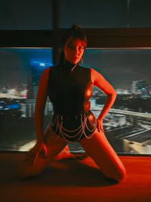 Styling of the keyhole latex bodysuit worn with a belt as a focal point