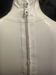 Close detail of the white latex mini skirt finish and fit of the set