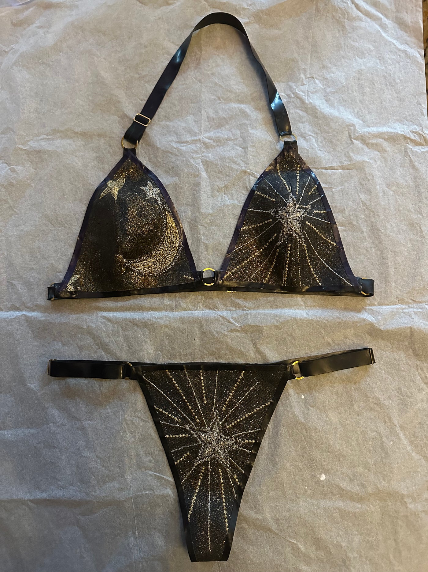 Detail of the shimmering celestial glitter-mesh latex bikini and gold hardware