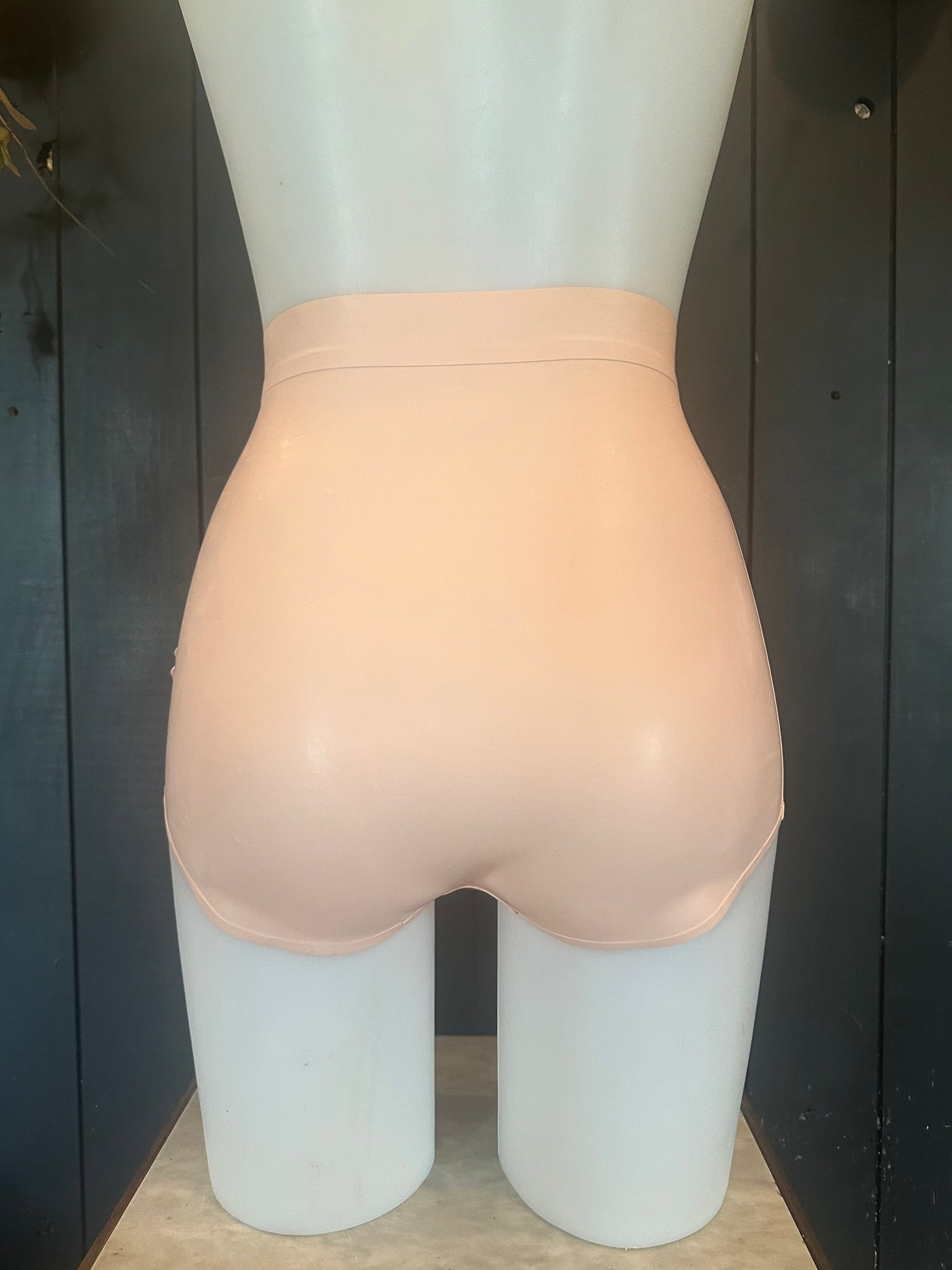 Close detail of the trim and waistband on the baby pink latex briefs