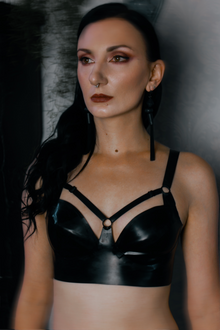 Detail of the adjustable harness straps across the chest on the latex bra