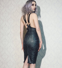 Close detail of the adjustable harness straps on the latex-lace cincher dress