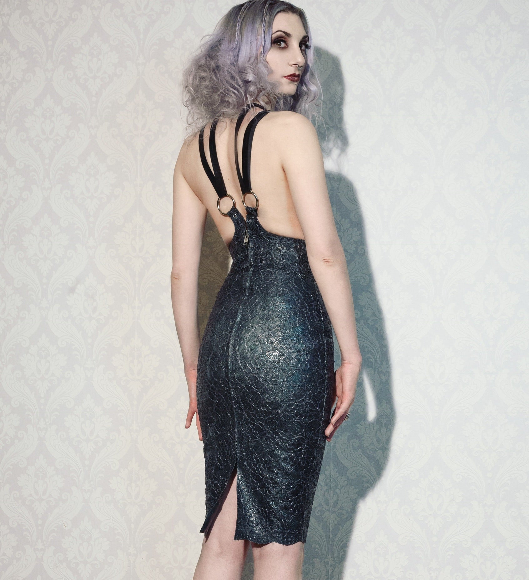 Close detail of the adjustable harness straps on the latex-lace cincher dress