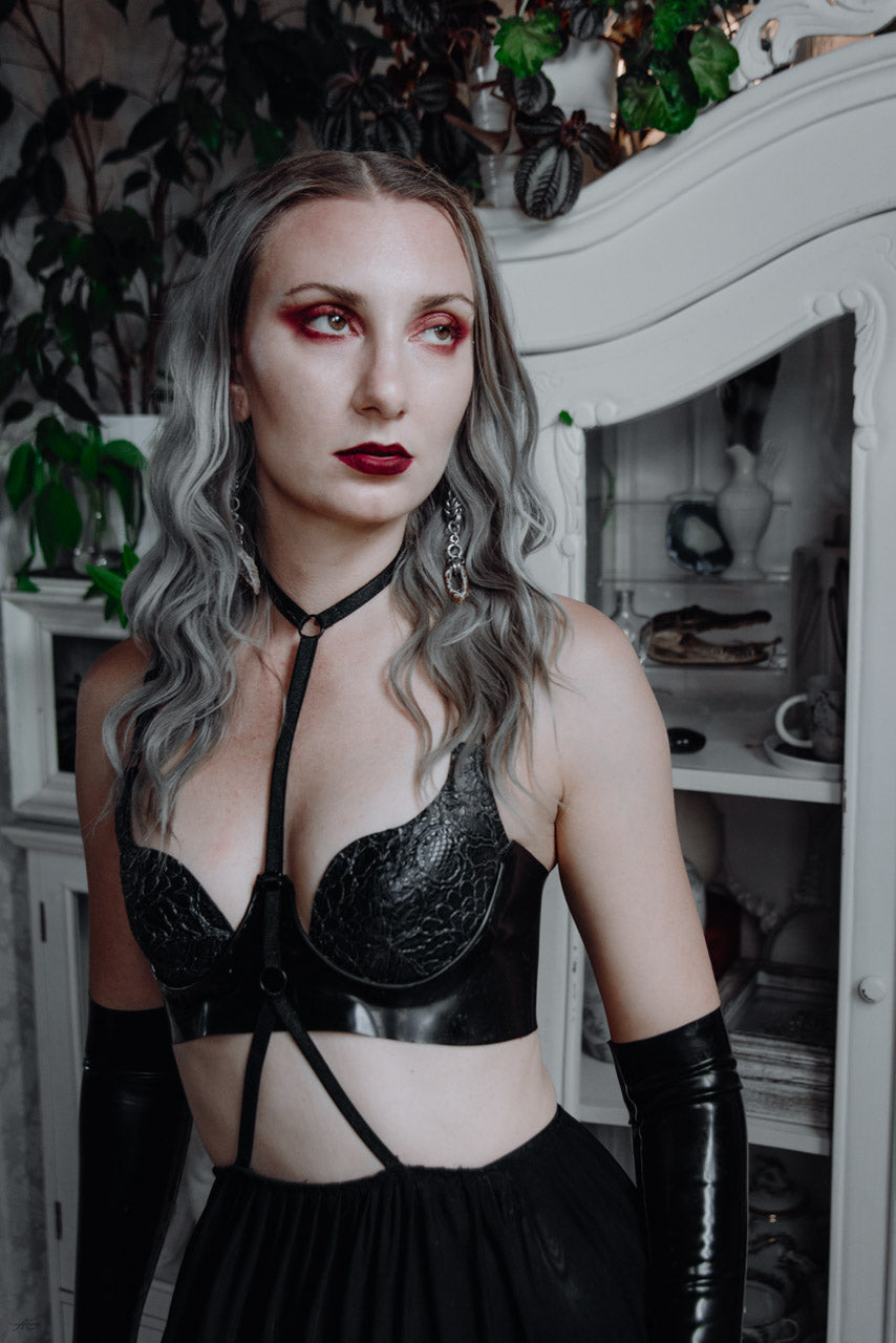 Close detail of the centre-back fastening on the latex-lace bra