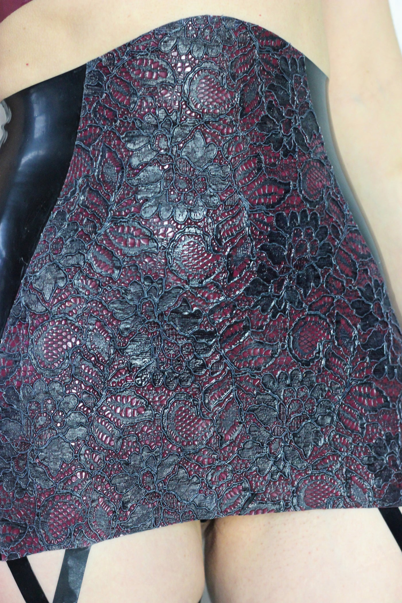 Texture detail of the latex-lace panel on the suspender girdle