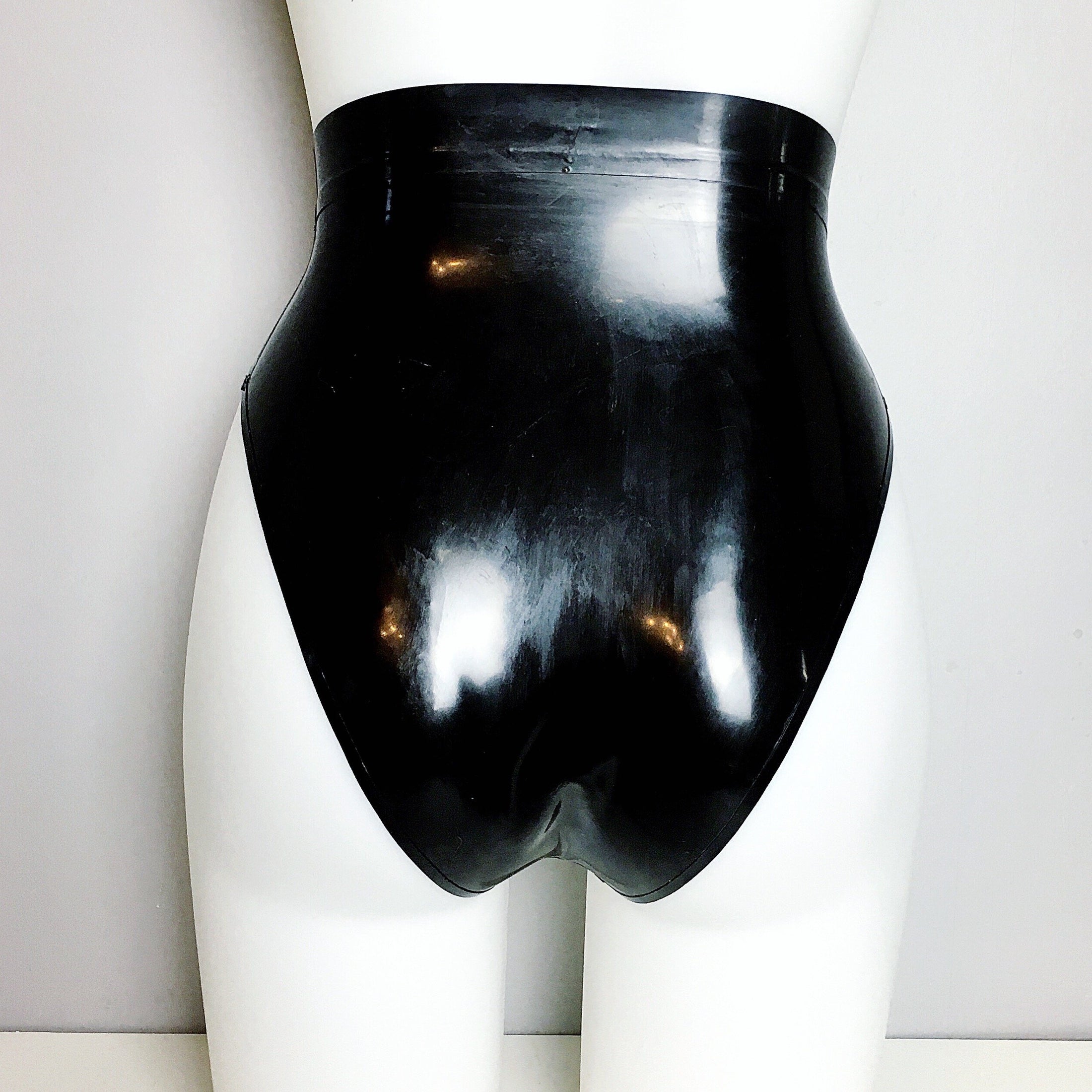 Texture detail of the smooth black latex and trimmed edges on the briefs