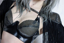 Close detail of the fringing on the textured latex-net shoulder pads